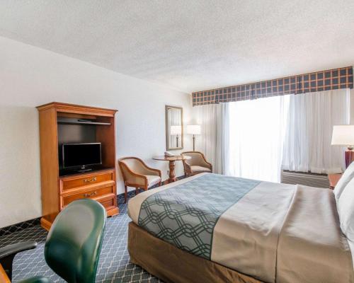 a hotel room with a bed and a television at North Miami Beach Gardens Inn & Suites in North Miami