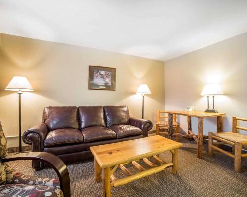 a living room with a leather couch and a table at The Antler Lodge - Gardiner in Gardiner