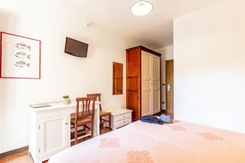 a bedroom with a bed and a desk and a chair at Hotel Santa Maria in Santa Maria Navarrese