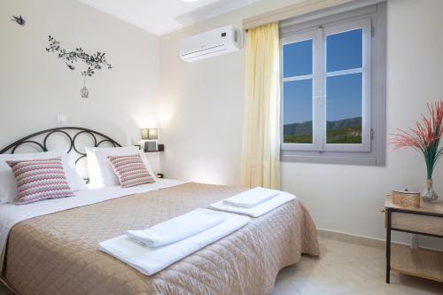a bedroom with a large bed with towels on it at George Poros house in Poros