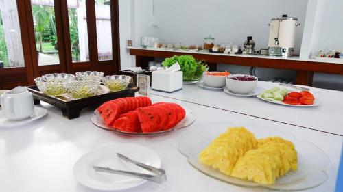 a table with plates of food on top at Baan Imm Sook Resort in Chao Lao Beach