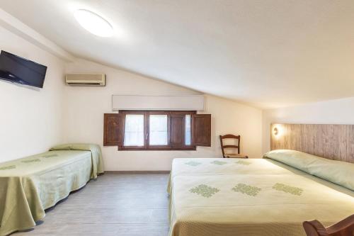 a bedroom with two beds and a window at Hotel Santa Maria in Santa Maria Navarrese