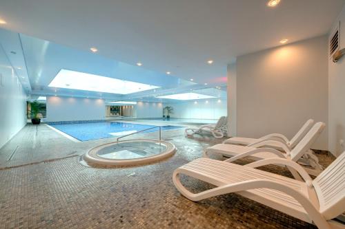 a swimming pool with two lounge chairs and a swimming pool at 3 City Apartments - Waterlane Valhalla in Gdańsk