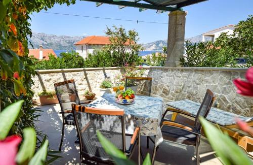 a table with a bowl of fruit on a patio at Apartments Gracija in Povlja