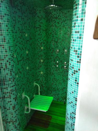 a green tiled bathroom with a green bench at Bad-wiessee Apart Hotel & Spa in Villa General Belgrano