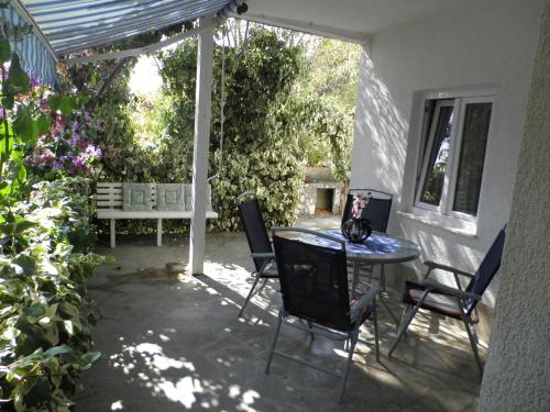 d'une terrasse avec une table, des chaises et un banc. dans l'établissement Apartments Rinčić, à Marina