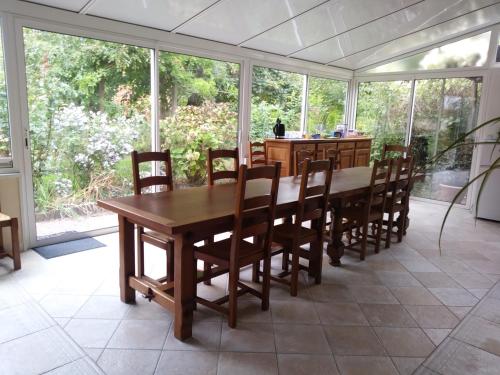 a dining room with a wooden table and chairs at GITE LES HAUTES MOUGONNIERES in Neuil