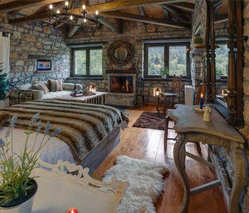a bedroom with a large bed and a stone wall at Μαγεμένο Βουνό in Karpenision