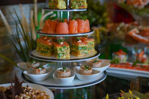 a three tiered display of food on a table at Ramada Encore by Wyndham Kuwait Downtown in Kuwait