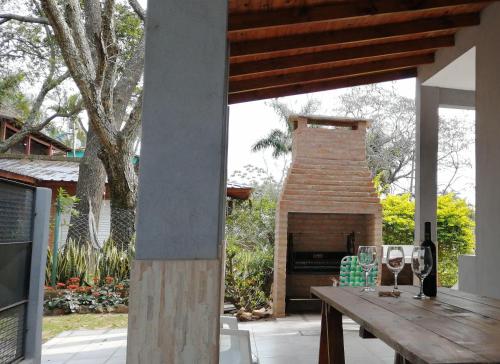 patio con chimenea de ladrillo y mesa de madera en Las Piedras del Paso en Paso de la Patria