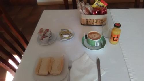una mesa blanca con comida y bebidas. en El Albergue Covaleda, en Covaleda