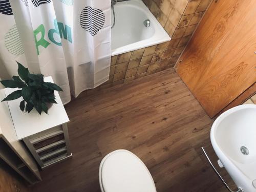 e bagno con servizi igienici, lavandino e vasca. di Lärchenwald Lodge a Bellwald