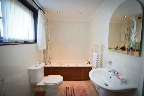 a bathroom with a tub and a toilet and a sink at An Cala in Connel