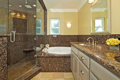 a bathroom with a tub and a sink and a shower at Ocean Palms Beach Resort in Carlsbad