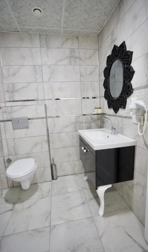 a bathroom with a toilet and a sink and a mirror at Cnr İnci Hotel in Istanbul