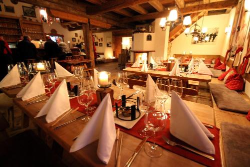 a long wooden table with wine glasses and napkins at Montana Hochfügen in Hochfugen