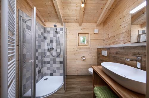 a bathroom with a tub and a toilet and a sink at Knaus Campingpark Lackenhäuser in Neureichenau