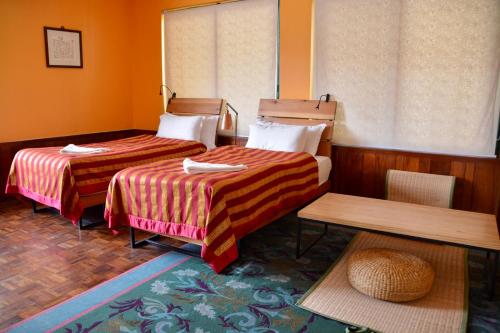 a hotel room with two beds and a window at Dondrub Guest House in Kathmandu