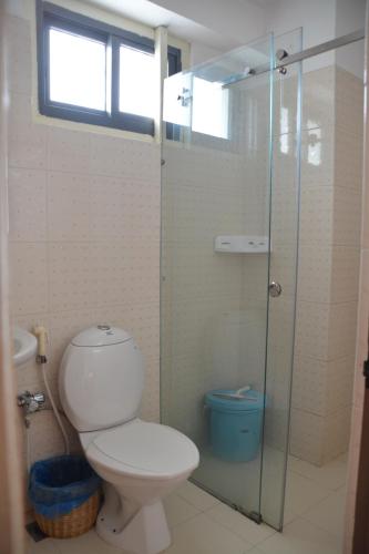 uma casa de banho com um WC e uma cabina de duche em vidro. em Dondrub Guest House em Catmandu