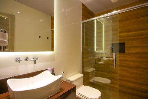 uma casa de banho com um lavatório, um WC e um chuveiro em Motel Golf (Adult Only) em Osasco