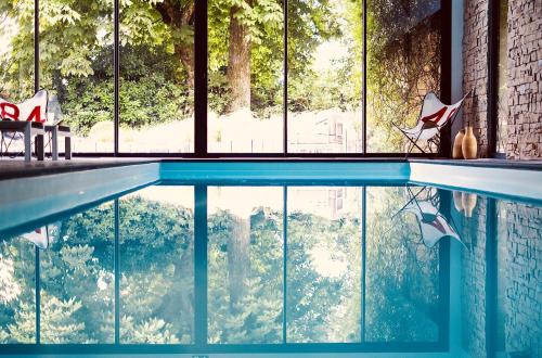 a swimming pool in a house with a large window at Manoir des Eperviers in Quéven