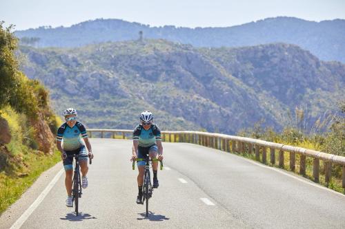 two people riding bikes down a road at Hotel Amic Horizonte in Palma de Mallorca