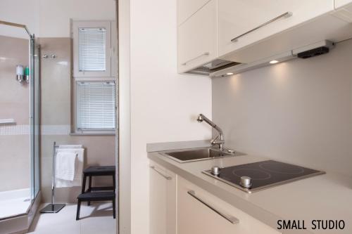 a small kitchen with a sink and a refrigerator at Donna Caterina in Sorrento