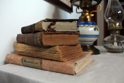 una pila di vecchi libri appoggiati su un tavolo di Casa Paz do Outeiro a Paredes de Coura