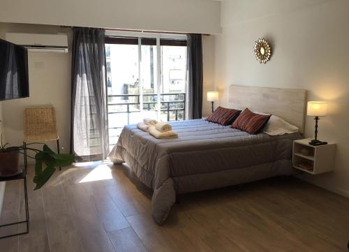 a bedroom with a large bed with a large window at Moderno apartamento en excelente ubicación in Buenos Aires