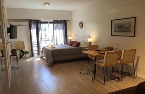 ein Schlafzimmer mit einem Bett und einem Tisch sowie ein Esszimmer in der Unterkunft Moderno apartamento en excelente ubicación in Buenos Aires