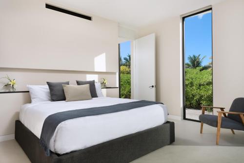 1 dormitorio con cama grande y ventana grande en UXUE Villa, en Long Bay Hills