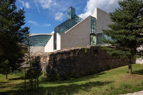 a building with glass windows on top of a stone wall at Melia Luxembourg in Luxembourg