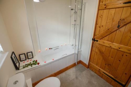 a bathroom with a tub and a toilet and a shower at Achalic Beag in Lerags