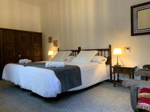 a bedroom with a large bed with white sheets and pillows at Inés Casa Rural in Almodóvar del Campo