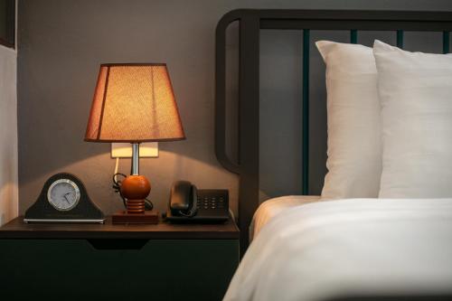 a hotel room with a bed and a lamp and a phone at Tam Coc Holiday Hotel & Villa in Ninh Binh
