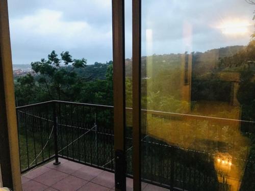 a room with a balcony with a view of the forest at Seabreeze Modern Apartment sleeps up to 4 people in Durban