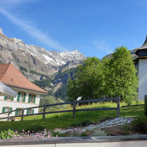 a house with a fence in front of a mountain at Hotel Bären in Gsteig