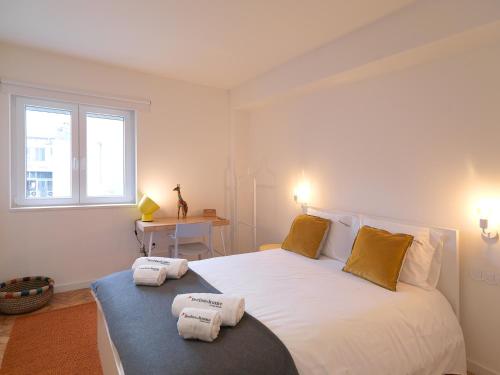 ポルトにあるFLH Porto Central Apartmentのベッドルーム1室(大きな白いベッド1台、タオル付)