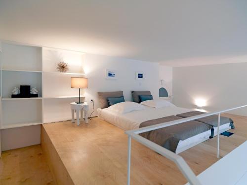 een witte slaapkamer met een bed en een bureau bij FLH Porto Modern Flat in Porto