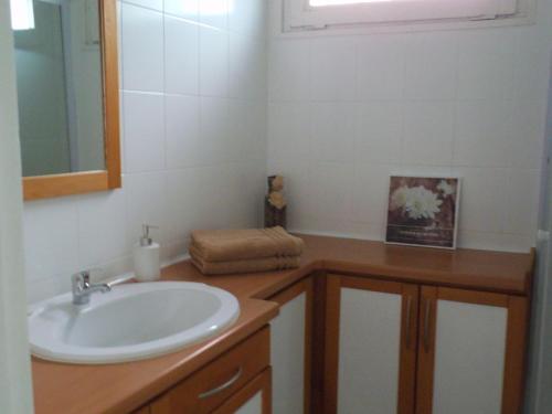W łazience znajduje się umywalka i lustro. w obiekcie Au Bougainvillier w Perpignanie