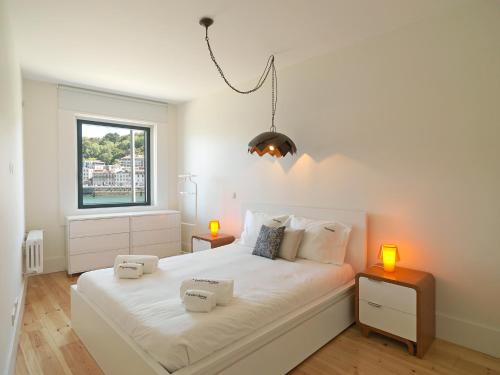 FLH Luxury Porto River View في فيلا نوفا دي غايا: غرفة نوم بسرير ابيض كبير عليها انارتين
