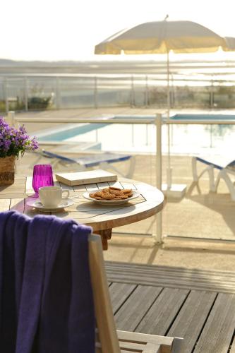 a table with a plate of food and an umbrella at Pierre & Vacances Premium Résidence de la Plage in Le Crotoy