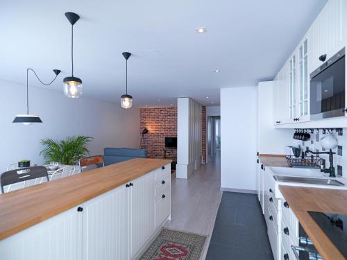 ポルトにあるFLH Porto Trindade Cozy Flatの白いキャビネット付きのキッチン、ダイニングルーム