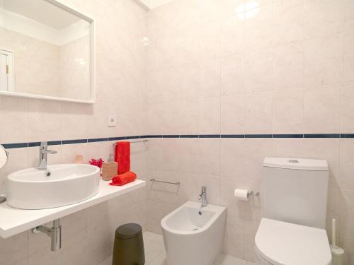 a white bathroom with a sink and a toilet at FLH Porto Comfort Flat in Porto