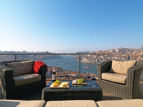 un balcón con 2 sillas y una mesa con comida. en FLH - Porto Vista House, en Vila Nova de Gaia