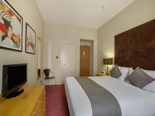 a hotel room with a bed and a television at OYO Flagship Brentwood in Aberdeen