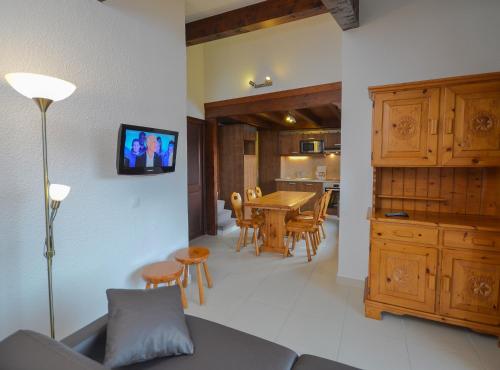 a living room and kitchen with a couch and a table at VVF Résidence Megève Mont-Blanc in Megève