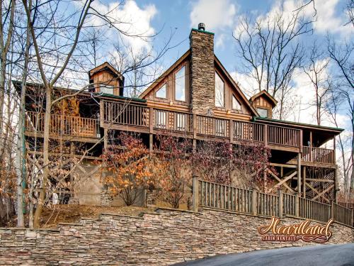 a home with a wrap around deck on a brick wall at Bear Hug Cabin Gatlinburg Convenient to Everything! in Gatlinburg