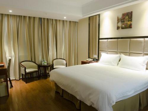 a hotel room with a large bed and a desk at Greentree Inn Changzhou Changwu Gufang Road Express Hotel in Changzhou