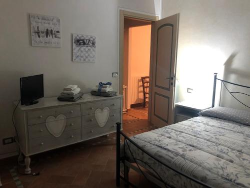a bedroom with a bed and a dresser with a television on it at Casa in campagna a due passi dal mare in Pisa